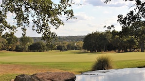 A golf course with a pond, trees, and a clear sky. - SUN CITY GEORGETOWN, TX RESORT - STUNNING CONTEMPORARY! (Georgetown)