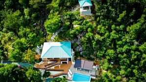 Ein Resort mit Schwimmbad, einer überdachten Terrasse und einem kleinen Gästehaus.