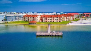 Um hotel à beira-mar com vários edifícios, um cais e uma vista desobstruída do oceano.