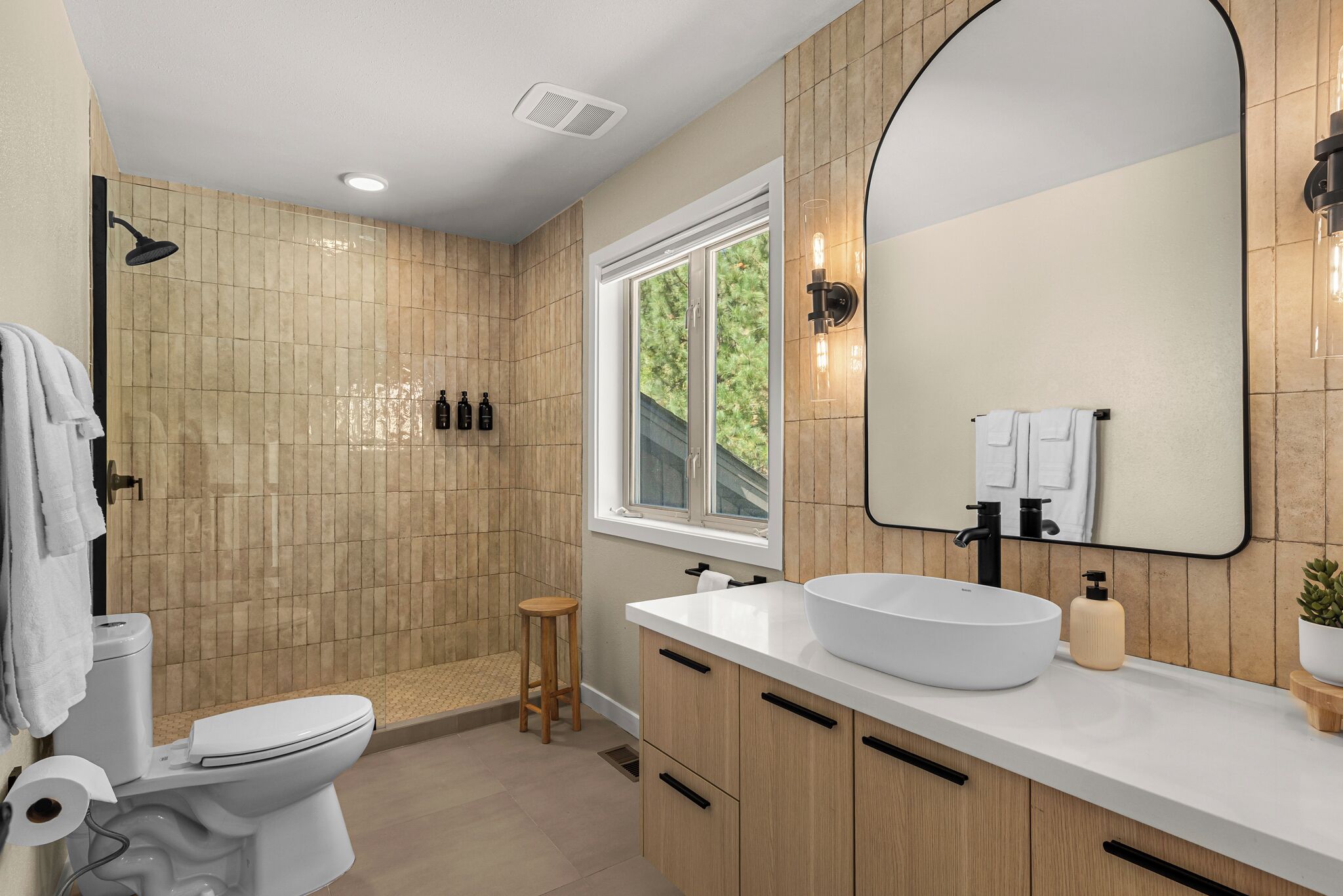 Un baño moderno con inodoro, lavamanos y ducha.
