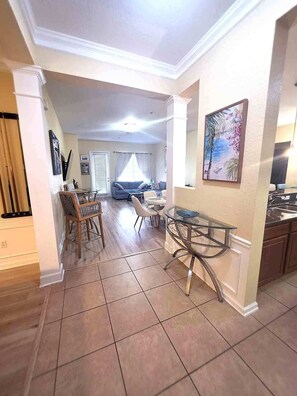 A spacious living area with a dining table, chairs, and a sofa.