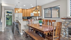 Une cuisine spacieuse avec des meubles en bois, un îlot central et un coin repas avec des bancs.