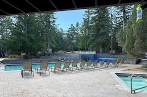 A poolside area with lounge chairs, a small pool, and a waterfall feature.