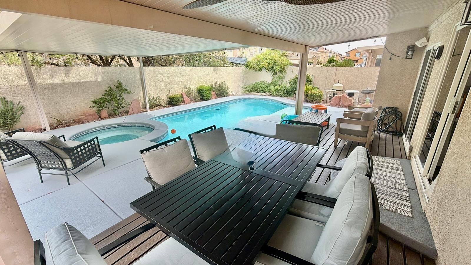 Un espace extérieur abrité comprenant une piscine, des sièges et un barbecue.
