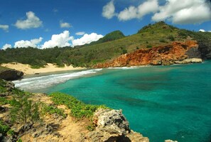 A coastal landscape with clear turquoise waters, sandy beach, and rocky cliffs. - 4 BDR, 3 BR, A/C, walk to beaches, restaurants and The Grand Hyatt (Koloa)