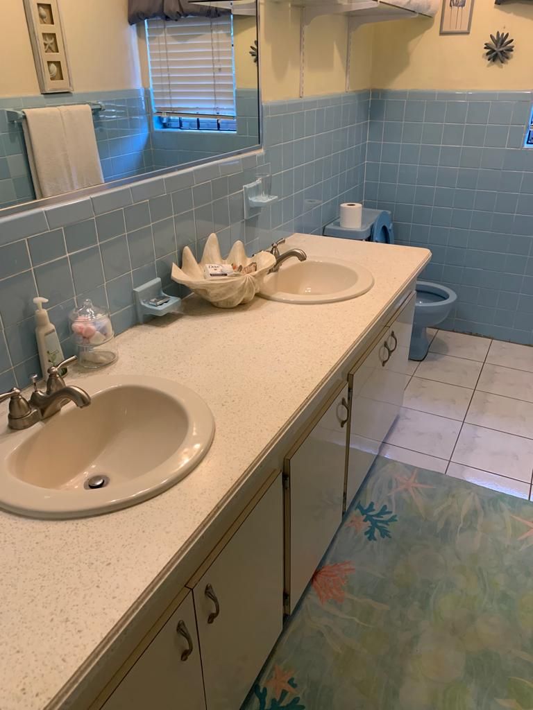 A bathroom with two sinks, a mirror, and a toilet.