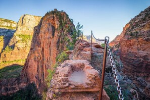 A rocky canyon with a chain-link fence and a metal post. - Private, well furnished, spacious, fenced, water park, Zion, golf, Sand Hollow (Hurricane)