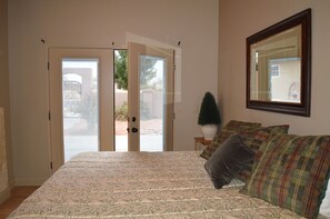 A bedroom with a bed, a mirror, and a door leading to an outdoor area. - Private, well furnished, spacious, fenced, water park, Zion, golf, Sand Hollow (Hurricane)