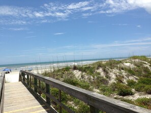 A wooden boardwalk leading to a beach with dunes and a clear blue sky. - Ocean front Condo ground level REMODELED (St. Augustine)