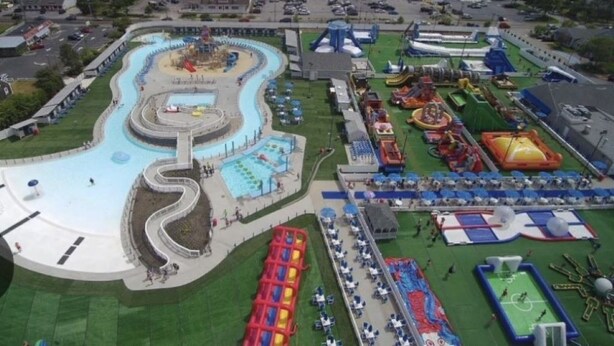 Een waterpark met een kronkelende waterglijbaan, meerdere zwembaden en diverse speelzones.
