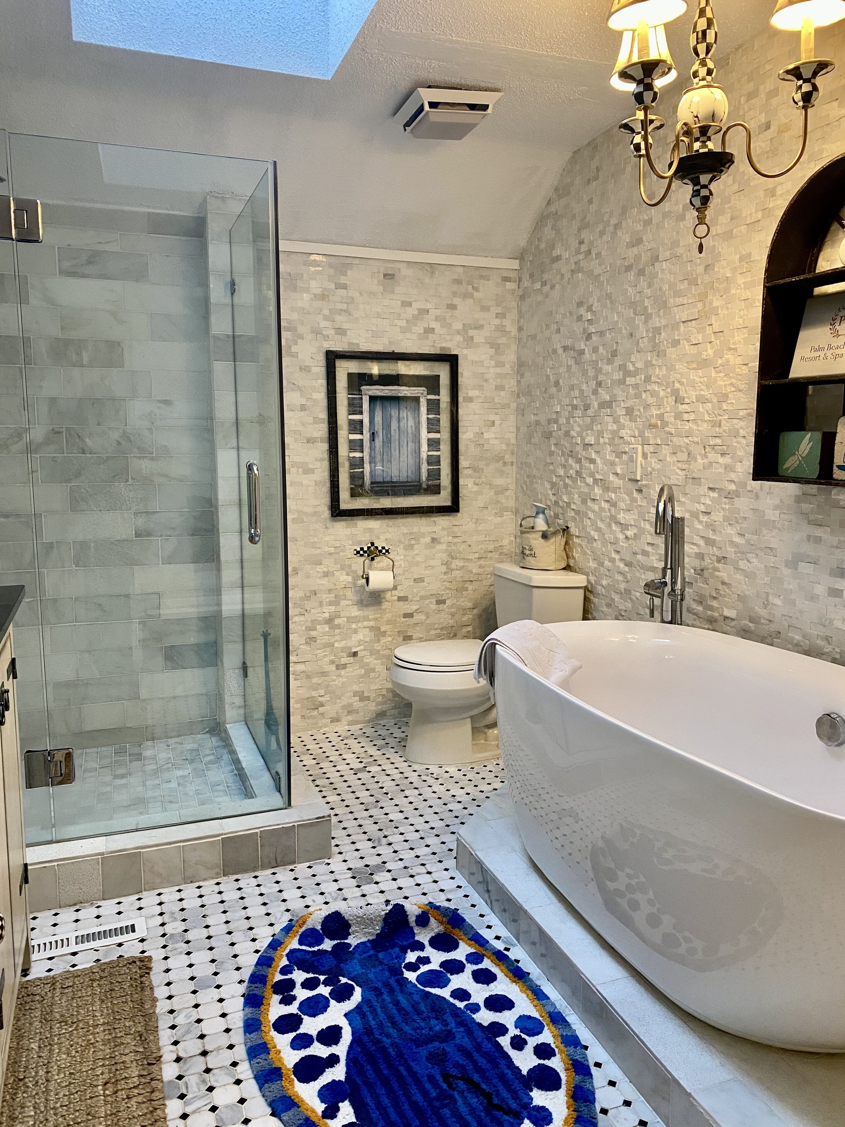 A bathroom with a glass shower enclosure, a freestanding bathtub, and a toilet.