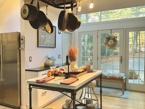 Kitchen features a central island, double sink, and ample cookware storage.