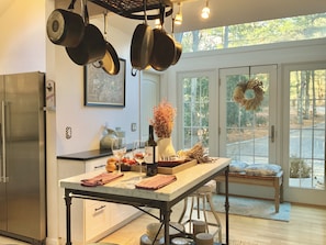 Kitchen features a central island, double sink, and ample cookware storage.