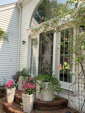 Stunning home exterior with a large window and a welcoming brick ledge featuring potted plants.