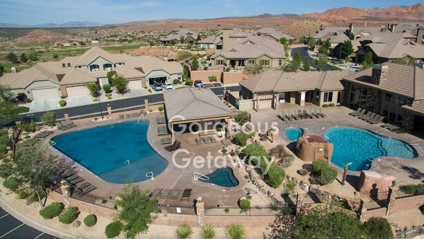 Un resort con varias piscinas, un patio cubierto y un telón de fondo montañoso.