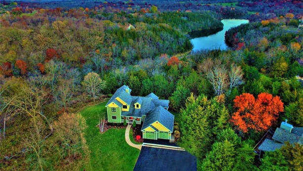 Une grande maison avec un vaste jardin et une vue sur une rivière.