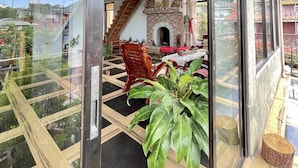 Un balcon spacieux doté d’un plancher en verre, d’un plafond en bois et offrant une vue sur le paysage urbain.