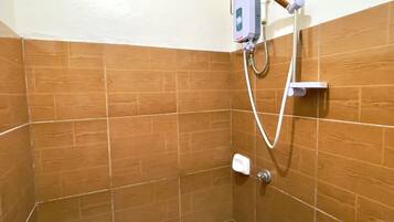 Un baño pequeño con azulejos, una ducha, un inodoro y un cubo.