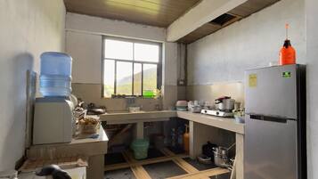 A kitchen with a refrigerator, sink, and window.