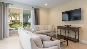 A modern living room with a large sofa set, a coffee table, and a flat-screen TV mounted on the wall. - Aco255240 - The Encore Club Resort - 8 Bed 7 Baths Villa (Kissimmee)