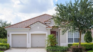 A single-story house with a tiled roof, two garage doors, and a well-maintained lawn. - Fv64670 - Windsor Hills Resort - 4 Bed 4 Baths Villa (Kissimmee)