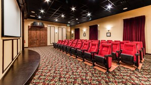 A theater with rows of red seats, a stage, and a patterned carpet. - Fv53300 - Paradise Palms - 4 Bed 3 Baths Townhome (Kissimmee)