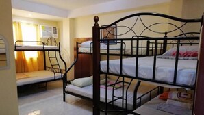 A dormitory room with bunk beds, a small desk, and a window with curtains. - Haus Of Tubo Pension House (Davao)