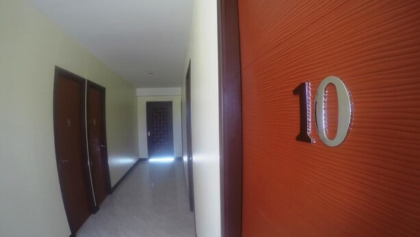 A hallway with a door marked '10' leading to a room. - Haus Of Tubo Pension House (Davao)
