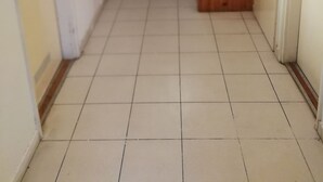A corridor with tiled flooring and wooden doors. - Ark-otel is not a hotel, but flat in an apartment building with 7 rooms.  (Gyor)