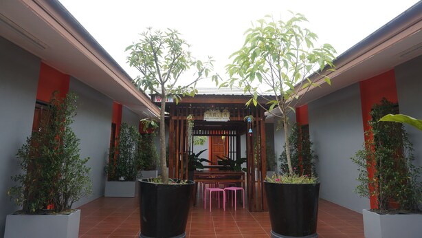 A covered outdoor seating area with a wooden pergola, potted plants, and a tiled floor. - Thai House Hotel & Resort Hat Yai (Hat Yai)