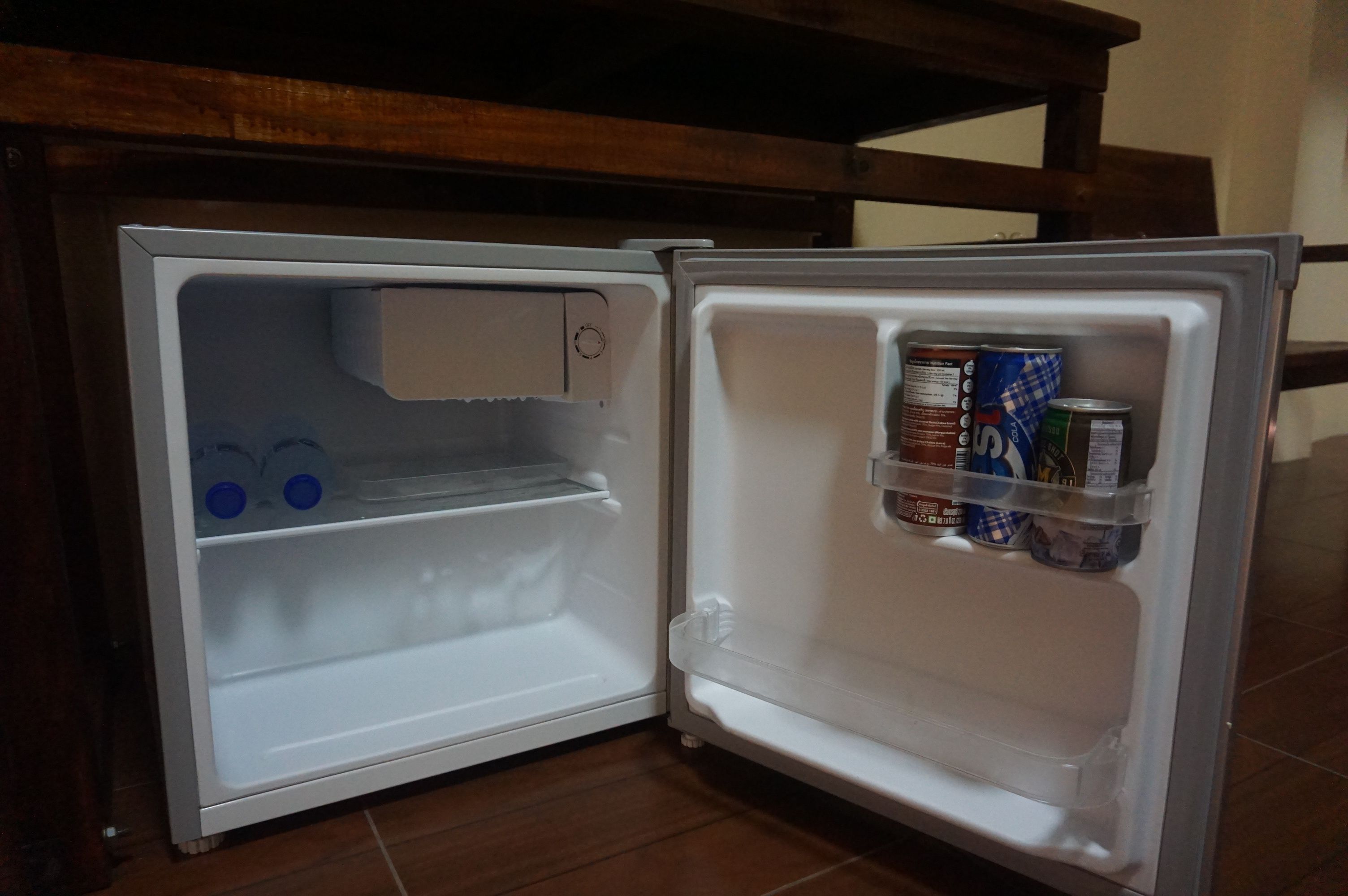 An open refrigerator with a few items inside, including a can and a carton.