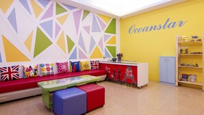 Un interior colorido con un sofá rojo, una mesa y una pared amarilla con la palabra "Oceanstar".