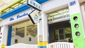 Un edificio con un letrero que dice "Ola Beaches" y el número "18" en la pared.