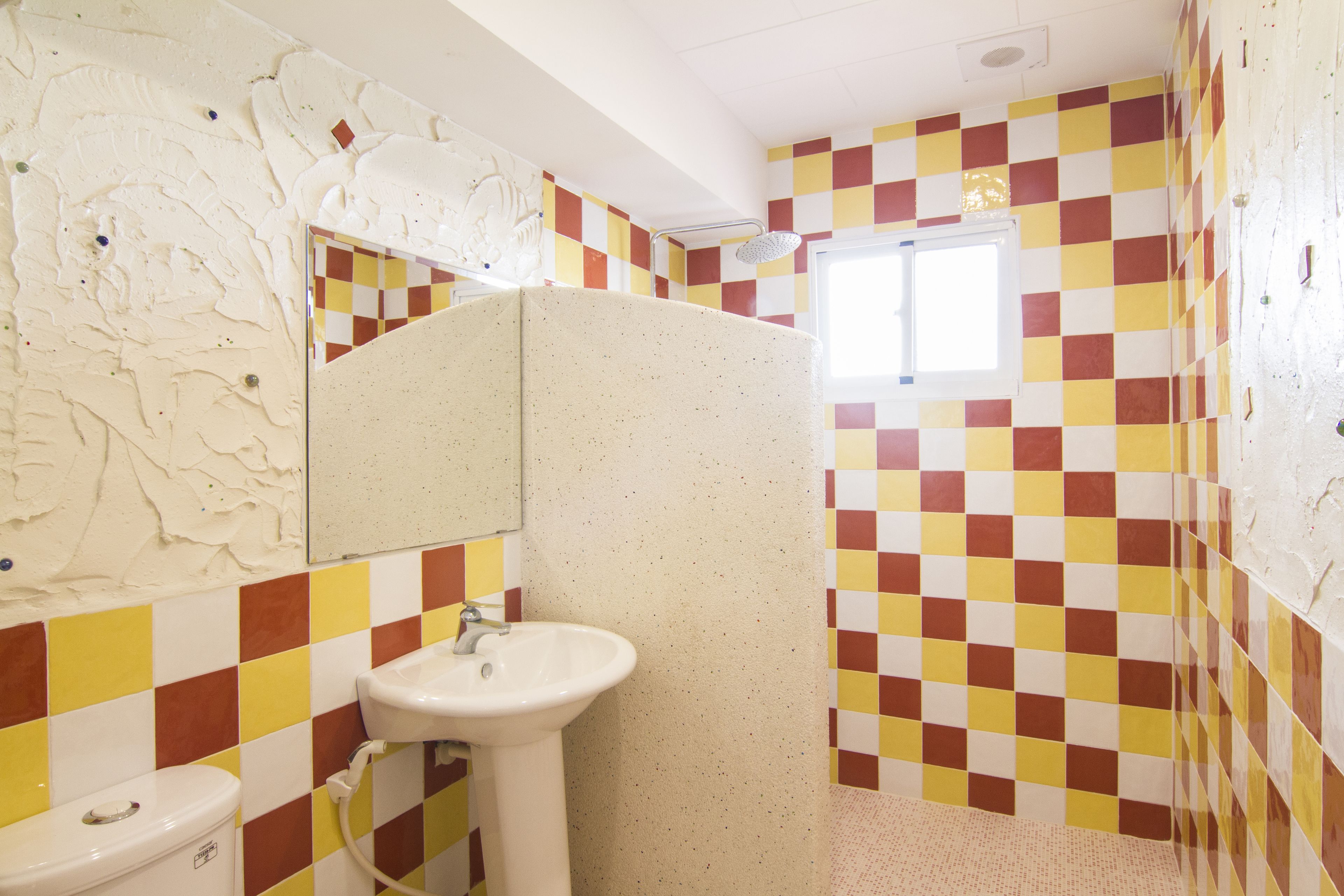 A bathroom with a checkered tile pattern, a white sink, and a toilet.