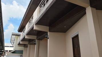A building with a traditional architectural style, featuring a balcony with ornate railings and a wooden ceiling.