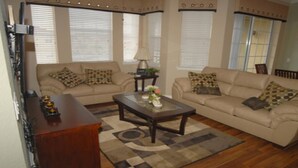 A living room with two beige sofas, patterned throw pillows, a wooden coffee table, and a decorative vase. - Tr421 - Terrace Ridge - 2 Bed 2 Baths Condo (Davenport)