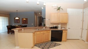 Enjoy cooking in this well-equipped kitchen with a central island, dishwasher, and coffee maker.