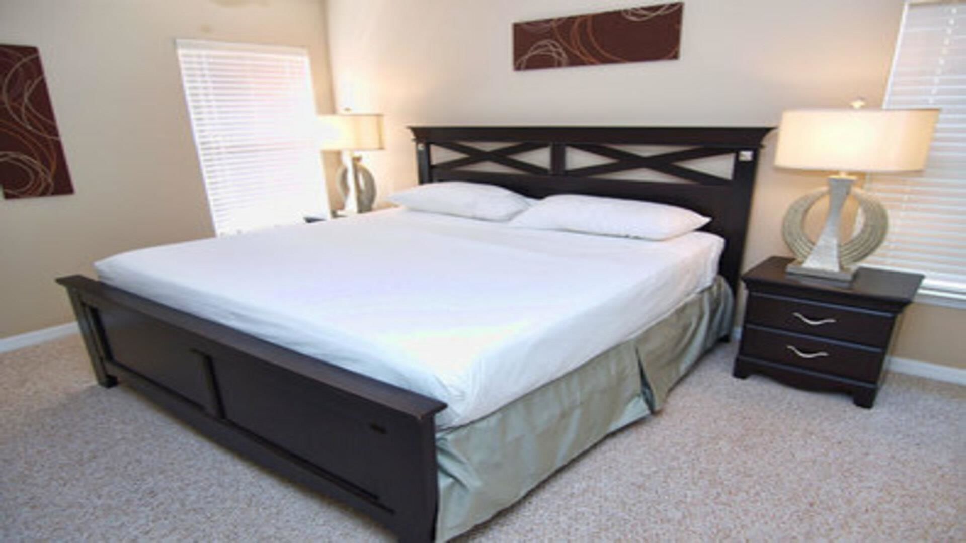 A bedroom with a bed, nightstands, and a lamp.