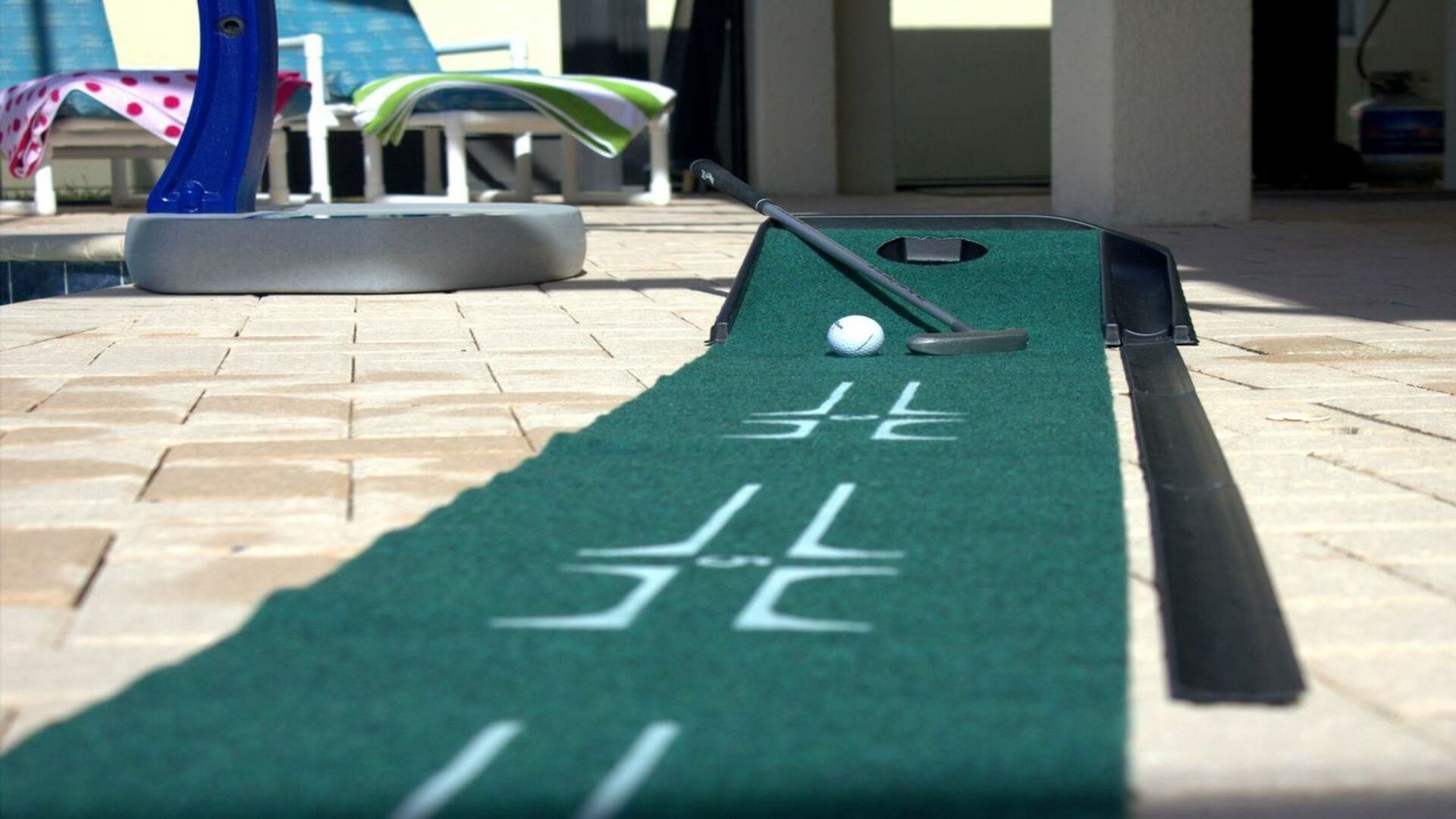 Uma mesa de shuffleboard com um disco e um bastão para manusear o disco, sobre um piso de azulejos.