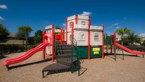 Ein Spielplatz mit roten Rutschen und einer Kletterkonstruktion.