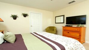 A bedroom with a bed, a dresser, a television, and two potted plants. - Wh2608 - Windsor Hills Resort - 6 Bed 4 Baths Villa (Kissimmee)