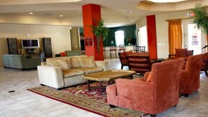 A spacious lobby with a sofa set, armchairs, a coffee table, and a TV. - Tr319 - Terrace Ridge - 2 Bed 2 Baths Condo (Davenport)