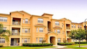 A multi-story residential building with balconies, a central courtyard, and a well-maintained lawn. - Tr319 - Terrace Ridge - 2 Bed 2 Baths Condo (Davenport)