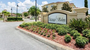 A sign for Terrace Ridge at Town Center, surrounded by landscaped gardens and a clear sky. - Tr319 - Terrace Ridge - 2 Bed 2 Baths Condo (Davenport)