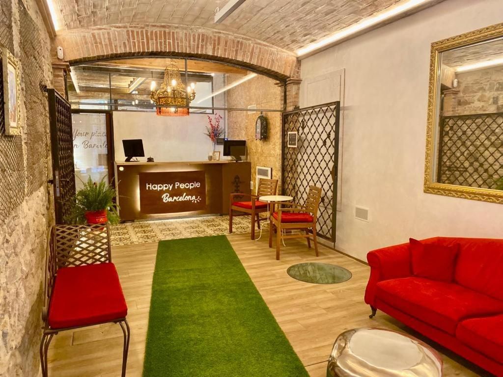 Un área de recepción con mostrador, un sofá rojo y césped artificial verde.