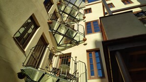 A multi-story building with balconies, a glass balustrade, and a clear blue sky. - Amfores Boutique Guest House (Barcelona)
