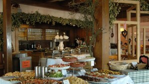 Un bufé con diferentes opciones de comida y una zona de bar con vasos y botellas.