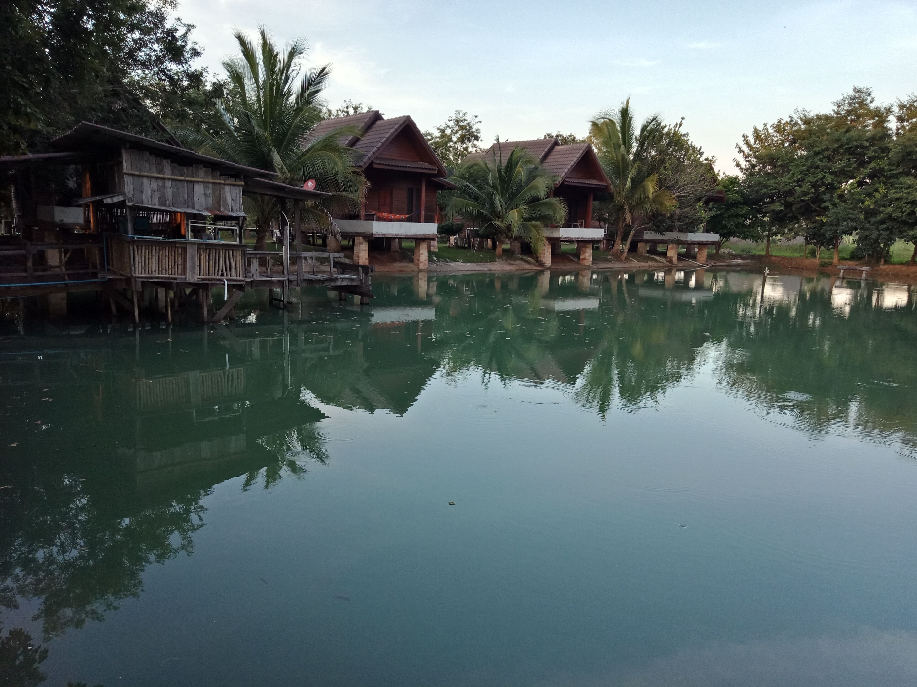 A tranquil lakeside setting with wooden houses and a wooden dock.