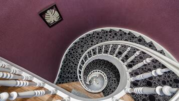 Un escalier en colimaçon à la forme circulaire, doté d’un plancher en bois.