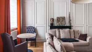 A living room with a round table, a sofa, and a chair. - La Maison du Champlain (Lille)